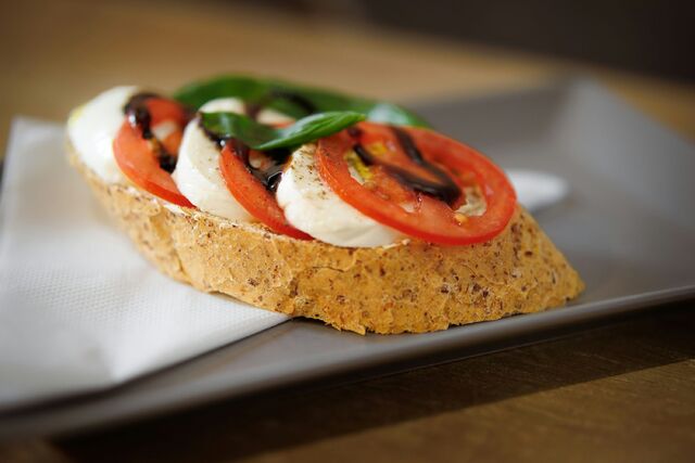 a piece of bread topped with cheese and vegetables